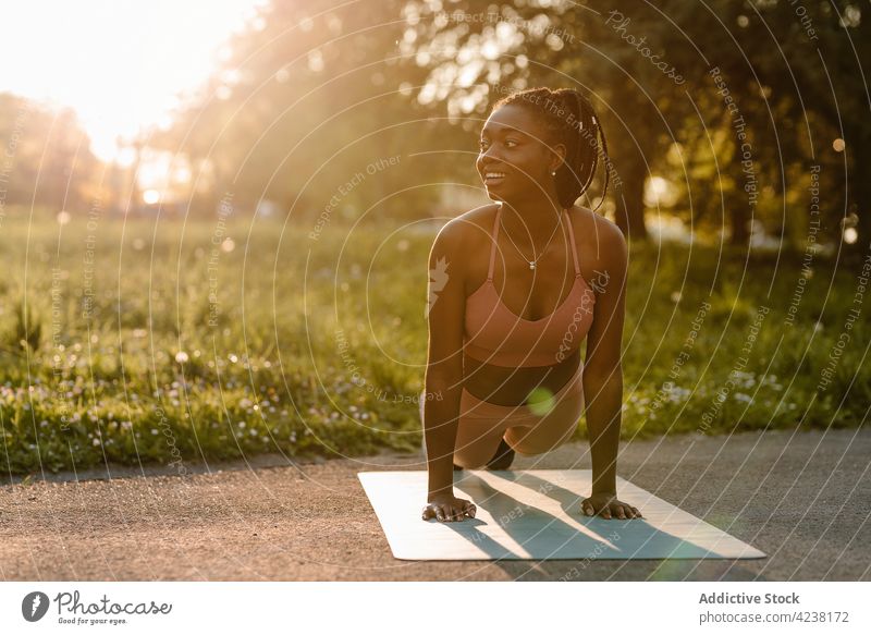 Schwarze Sportlerin beim Training im Park bei Sonnenuntergang Schiffsplanken Übung Gleichgewicht Bauchmuskeln passen Frau ethnisch schwarz Afroamerikaner Athlet