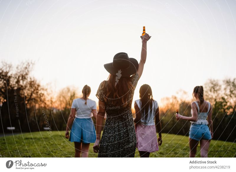 Eine Gruppe verschiedener Frauen genießt den Abend im Sommerpark genießen Bier Sonnenuntergang Park Mädchen Unternehmen Zusammensein sorgenfrei multiethnisch