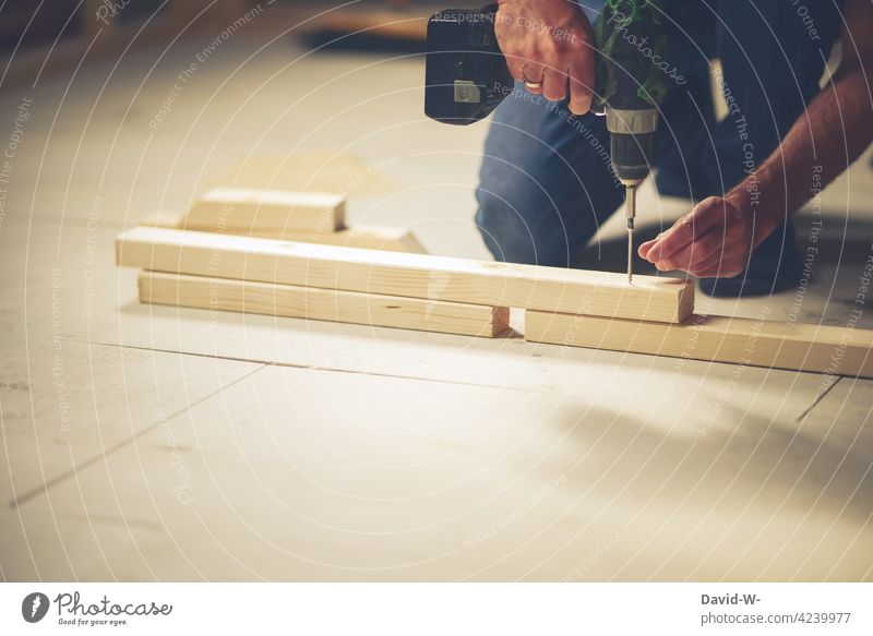 Mann werkelt mit einer Bohrmaschine Handwerker Werkzeug Arbeit & Erwerbstätigkeit Schraube bohren Holz Arbeitsplatz heimwerken Beruf Schreiner