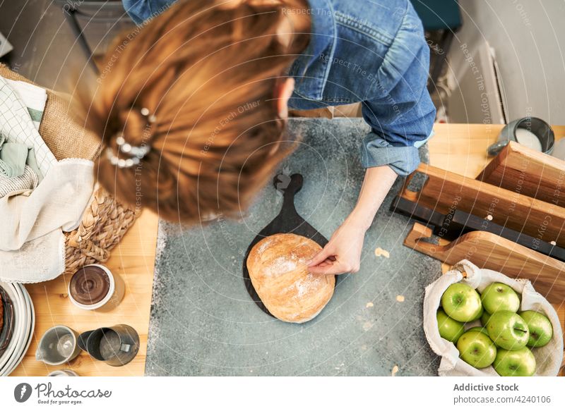 Gesichtslose Frau, die in der Küche Brot mit Mehl bestreut bestäuben gebacken frisch Rezept kulinarisch vorbereiten selbstgemacht Kruste Weizen Apfel Frucht