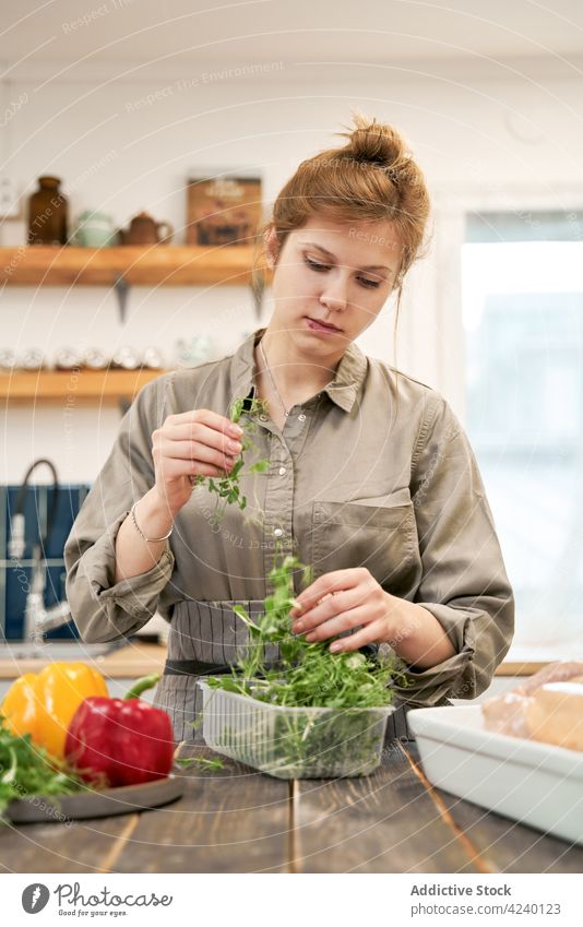 Frau mit Kressesprossen in einem Behälter in der Küche des Hauses Kraut gesunde Ernährung Gemüse Rezept kulinarisch Koch Porträt Paprika hell Kunststoff Kasten