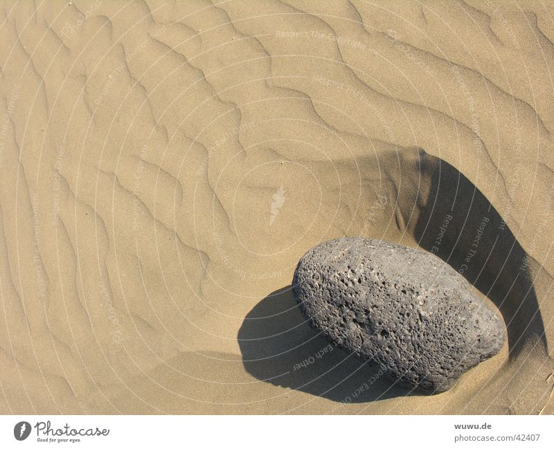 Stein im Sand Furche grau beige Wüste Schatten Fremdkörper