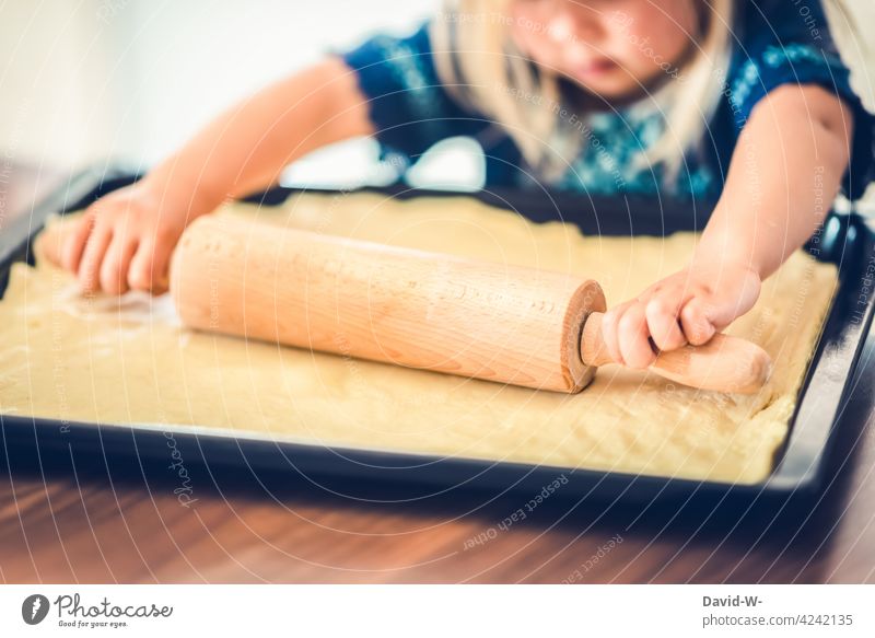 felißiges Mädchen rollt einen Teig aus Kind Küche fleißig arbeiten konzentriert backen Kuchen Pizza Nudelholz niedlich Essen zubereiten Kindererziehung