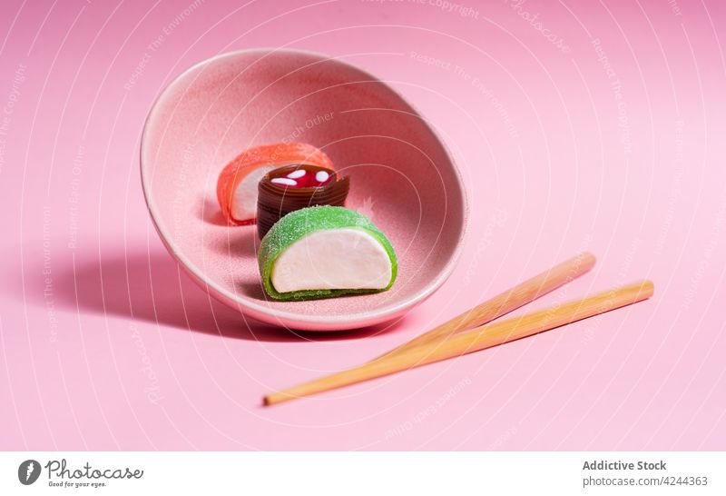 Leckeres Süßigkeiten-Sushi auf rosa Teller mit Stäbchen serviert süß Dessert Asiatische Küche Essstäbchen Mahlzeit Lebensmittel lecker Bonbon Tradition