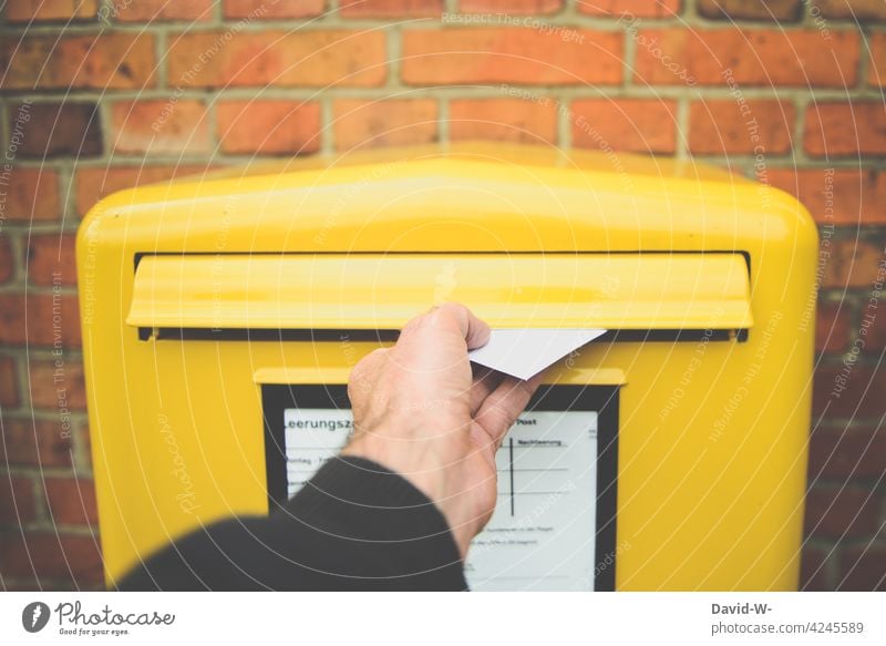 einen Brief in den Postkasten werfen Hand Briefkasten versenden verschicken Briefumschlag Nachricht gelb