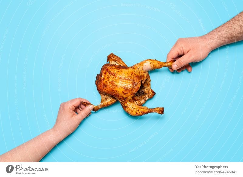 Essen gebratenes Huhn auf blauem Hintergrund. Menschen Hände packen Huhn. Essen teilen obere Ansicht gebacken Masthähnchen Hähnchen Weihnachten farbig Konzept