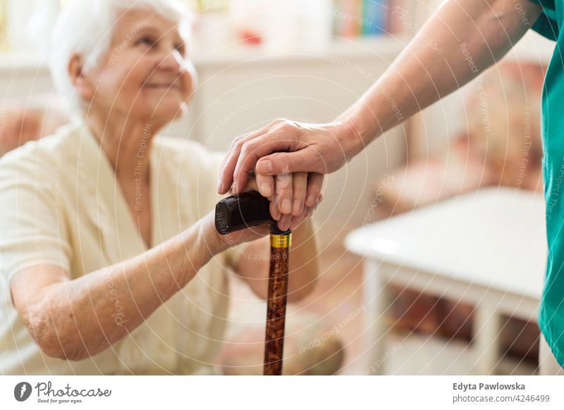 Krankenschwester tröstet ihre ältere Patientin, indem sie ihre Hände hält Menschen Frau Senior reif lässig Kaukasier heimwärts Haus Pflege alt Gesundheit