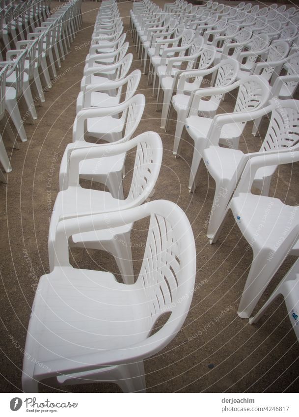 Ganz viele Weiße Plastik Stühle mit Lehne, stehen neben und hintereinander in Reih und Glied und warten auf die Besucher. Sperrung Pandemie Korona Schutz