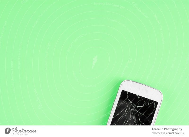 Ein kaputtes Touchscreen-Handy auf grünem Hintergrund mit Kopierraum für Text sehr wenige Verbraucher App gebrochen Business Anruf Zelle Chipsatz Konzept