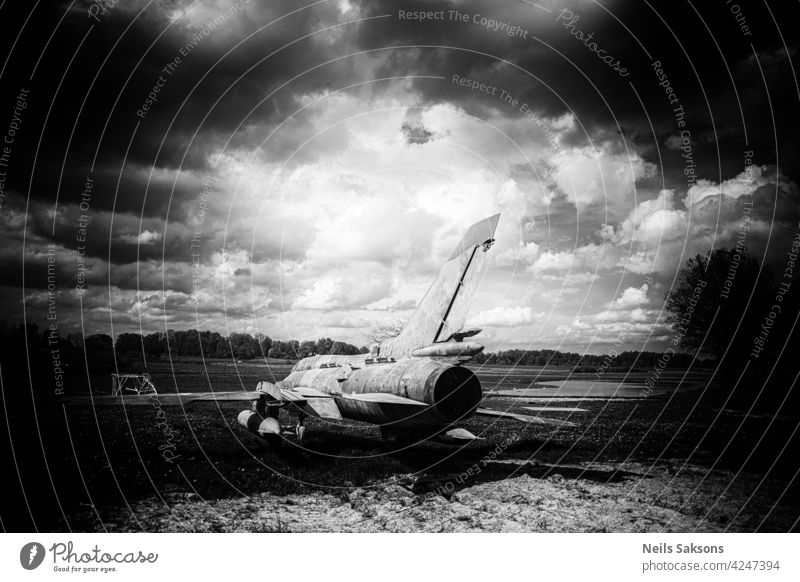 alte Vintage reaktive Flugzeug, Flugzeug im Feld mit Löwenzahn und Teich, bewölkten dramatischen Himmel in der Mitte des frühen Mai Tag Kunst Hintergrund schön