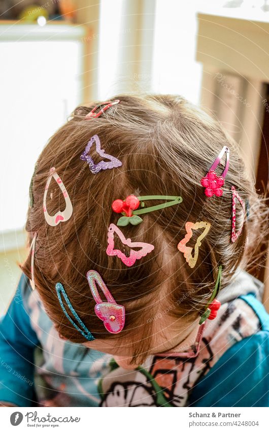Kind mit ganz vielen Haarspangen im Haar Haare Frisur ausprobieren neugierig mädchen schmücken Schmuck Haarklammern Kindheit Familienleben Kinder spielen
