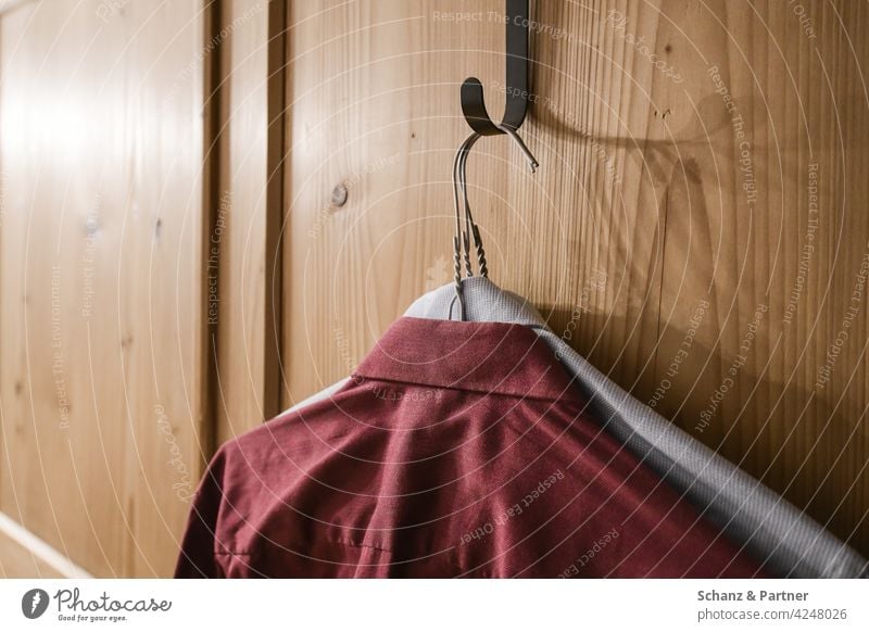 zwei Hemden hängen am Schrank bügeln kleiderbügel Kleiderschrank Kleidung vorbereiten Bekleidung packen gebügelt herrenhemden oberhemd kleiderschrank