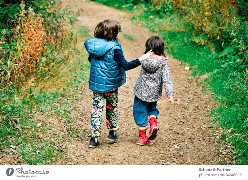 zwei Kinder schlendern durch den Wald wandern Freundschaft spazieren laufen Schwestern zusammen Familie draußen Natur Kindheit Mädchen Urlaub Wanderung