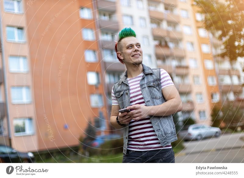 Junger Punk Mann mit Smartphone Porträt Erwachsene jung Menschen eine Person lässig Teenager männlich allein trendy Mode cool mohawk Behaarung farbenfroh Stil