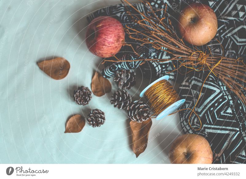 Äpfel, Eicheln und getrocknete Blätter auf einem weißen Hintergrund, der das Konzept der Herbstsaison und der Ernte zeigt Herbsternte Oktober September