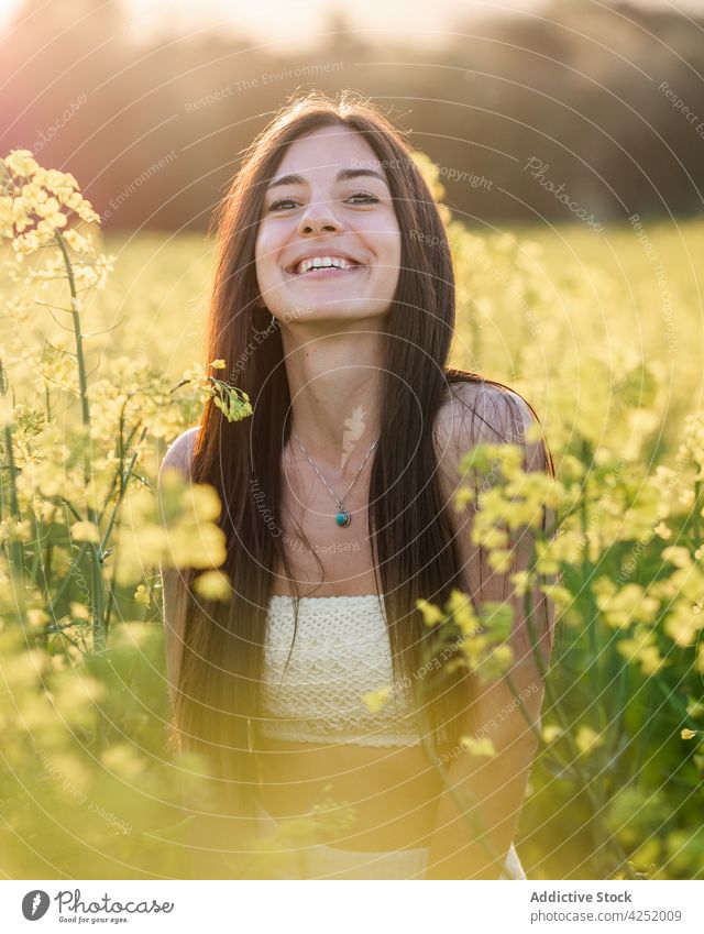 Fröhliche Frau auf grünem Feld stehend Lachen freudig Stil Blüte Sommer Natur sorgenfrei sonnig Freude Raps feminin Blütezeit Gelassenheit attraktiv schön
