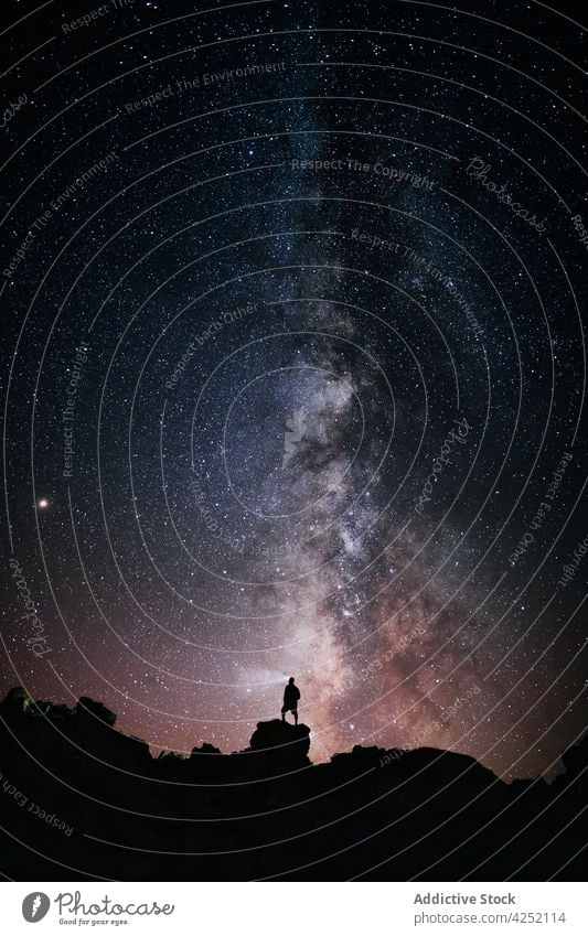 Reisender steht auf einem Felsen vor dem Sternenhimmel Mann Silhouette Nacht Klippe Astronomie Galaxie dunkel leuchten Milchstrasse männlich Natur sternenklar