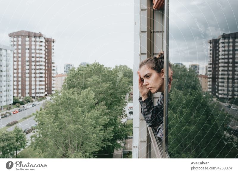 Frau besorgt, während das Fenster in der Stadt während eines Frühlingstages, psychische Gesundheit Konzept Angst Frustration Problematik traurig Traurigkeit