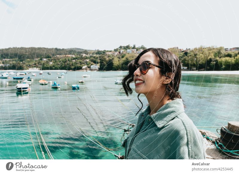 Junge Frau in einem Boot Dock lächelnd während eines sonnigen Tages, während mit Sonnenbrille Strand Tag Person Porträt allein Glamour Freude Sonnenlicht Jacht