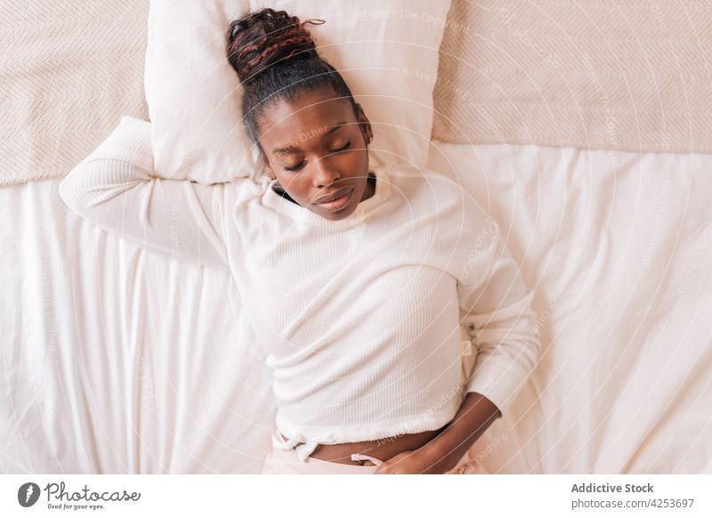 Junge schwarze Frau schläft auf einem bequemen Bett zu Hause schlafen Augen geschlossen sich[Akk] entspannen Lügen Schlafzimmer Kopfkissen schlafend Morgen