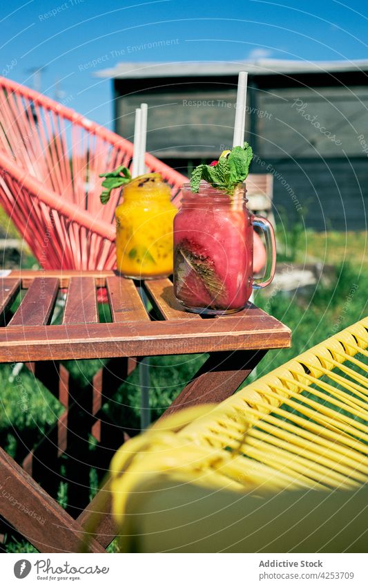 Gläser mit köstlich aromatisierten Mojito-Cocktails, die im Garten serviert werden Geschmack Erdbeeren Pfirsich klassisch alternativ verschiedene Alkohol