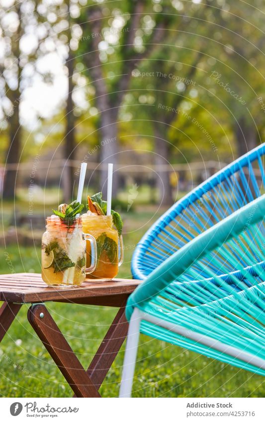 Gläser mit köstlich aromatisierten Mojito-Cocktails, die im Garten serviert werden Geschmack Erdbeeren Pfirsich klassisch alternativ verschiedene Alkohol