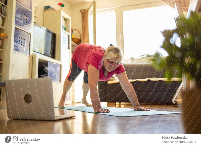 Ältere Frau trainiert zu Hause Brille Falte natürlich echte Menschen lässig Tag Lifestyle Großmutter Rentnerin gealtert Freizeit Ruhestand Lebensalter