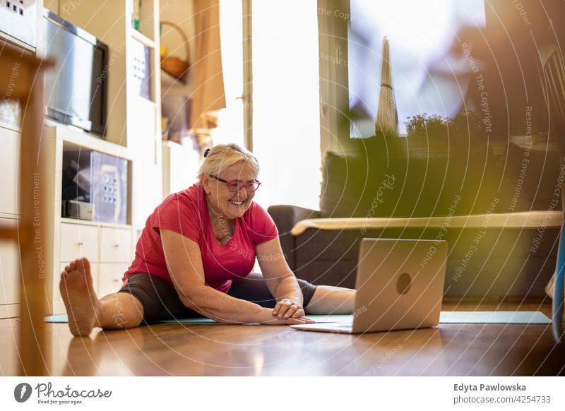 Ältere Frau trainiert zu Hause Brille Falte natürlich echte Menschen lässig Tag Lifestyle Großmutter Rentnerin gealtert Freizeit Ruhestand Lebensalter