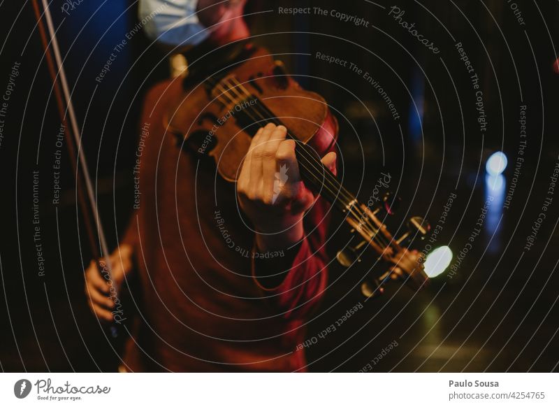 Mann mit Gesichtsmaske hält Geige Geiger Musik Musiker Instrument Klassik Farbfoto Schleife Kunst Konzert klassisch Musik hören Nahaufnahme musizieren Klang