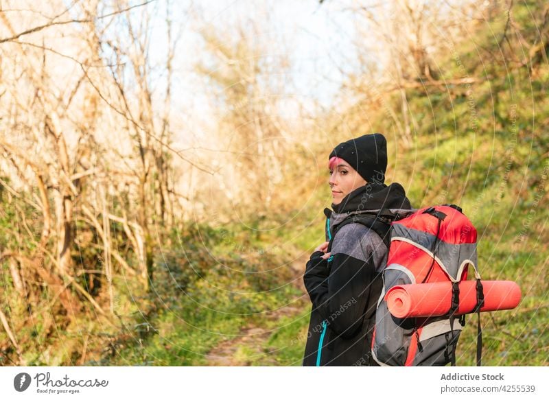 Fröhliche Frau, die beim Wandern in der Natur steht Wanderung Trekking Ausflug Wald Abenteuer Wanderer Tourismus Reise Rucksack reisen Reisender warme Kleidung