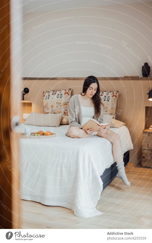 Gelassene Frau liest Buch auf weichem Bett Leseratte lesen Schlafzimmer Gelassenheit interessant genießen Etage Komfort Hobby Windstille ruhig zu Hause sitzen