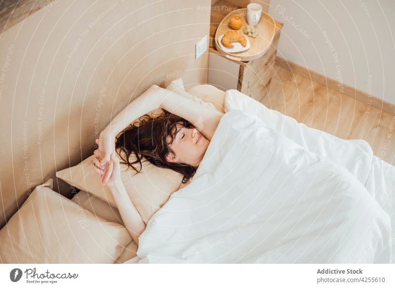 Junge Frau schläft friedlich auf einem gemütlichen Bett am Morgen schlafen Komfort sich[Akk] entspannen träumen Schlafenszeit schlafend Schlafzimmer Lügen