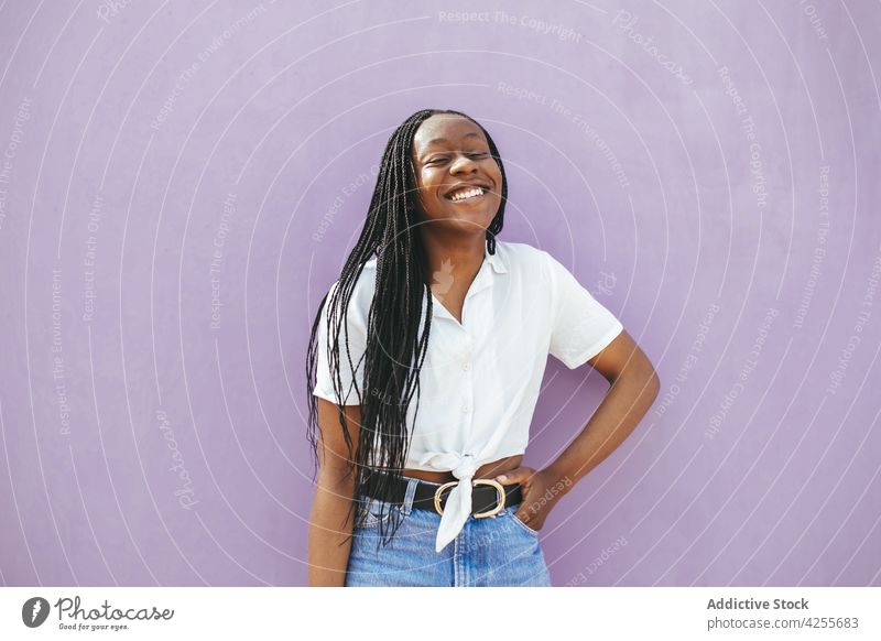 Lächelnde schwarze Frau in der Nähe der Wand stehend Mode Stil Glück sorgenfrei Stimmung Sommer Straße Freude lässig Afroamerikaner trendy Outfit Freizeit Stoff