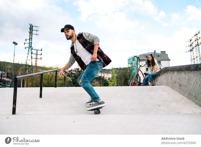 Mann in der Nähe einer Frau beim Üben auf Freeline-Skates heiter Freund Lächeln üben freeline Schlittschuh driften Zusammensein Aktivität Energie Stunt extrem