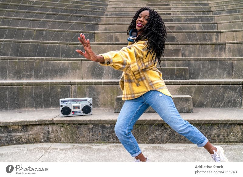 Schwarze Frau hört Musik und tanzt zuhören genießen Gesang Boombox unterhalten cool positiv Blaster tragbar retro altmodisch heiter lässig jung tausendjährig