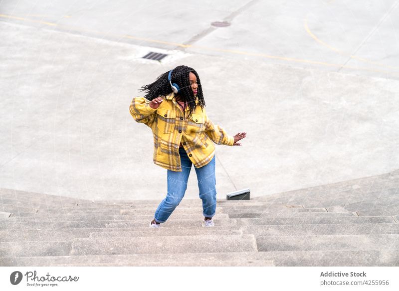 Aufgeregte schwarze Frau hat Spaß im Park Kopfhörer genießen Tanzen Glück aufgeregt Körperhaltung sorgenfrei Musik zufrieden Freude expressiv heiter