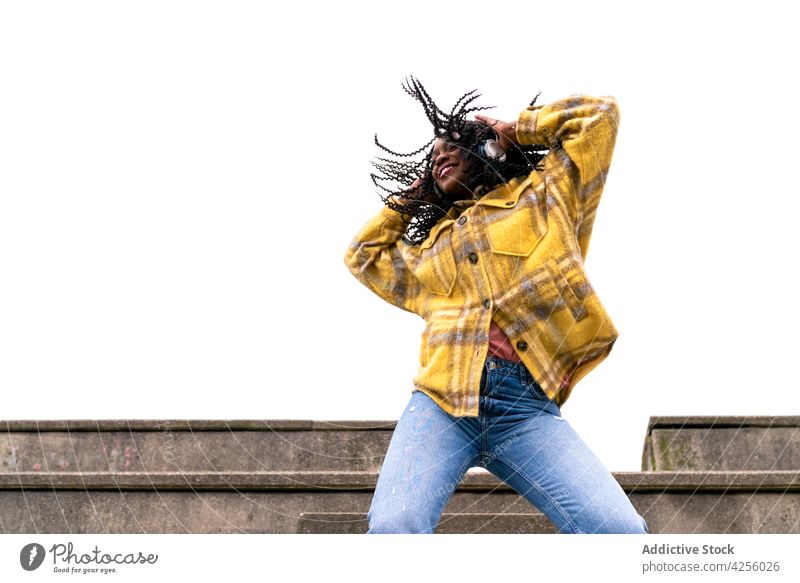 Energetische schwarze Frau tanzt auf Betongrenze sorgenfrei schütteln Tanzen sich[Akk] bewegen Freizeit Freestyle dynamisch Bewegung genießen Aktion