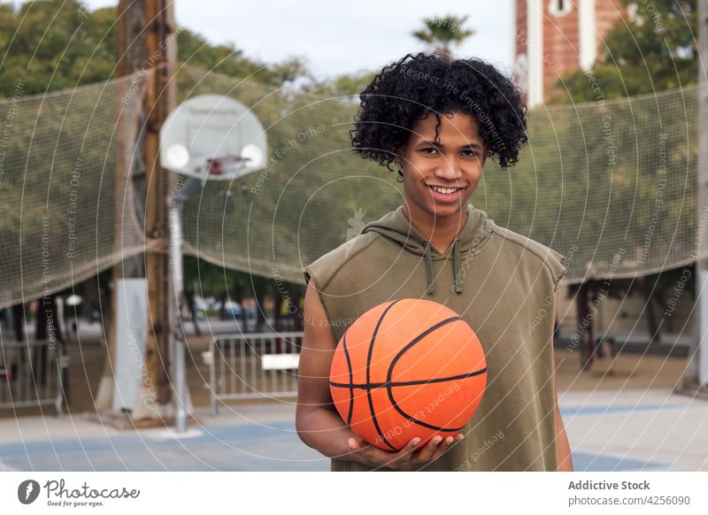 Schwarzer Mann stehend mit Basketball auf Sportplatz Spieler Teenager Ball Sportpark Hobby männlich Gericht Jugendlicher Freizeit Training jung Aktivität