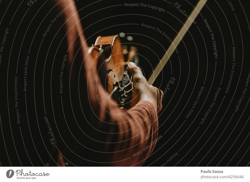 Nahaufnahme Hand hält Geige Geiger Musikinstrument Konzert Klassik Instrument Musiker Farbfoto Kunst Schleife Cello Schauplatz musizieren Streichinstrumente