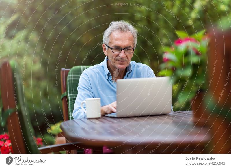 Senior Mann arbeitet am Laptop im Garten Computer Technik & Technologie arbeiten Internet benutzend Notebook alt Männer männlich heimwärts Haus Menschen