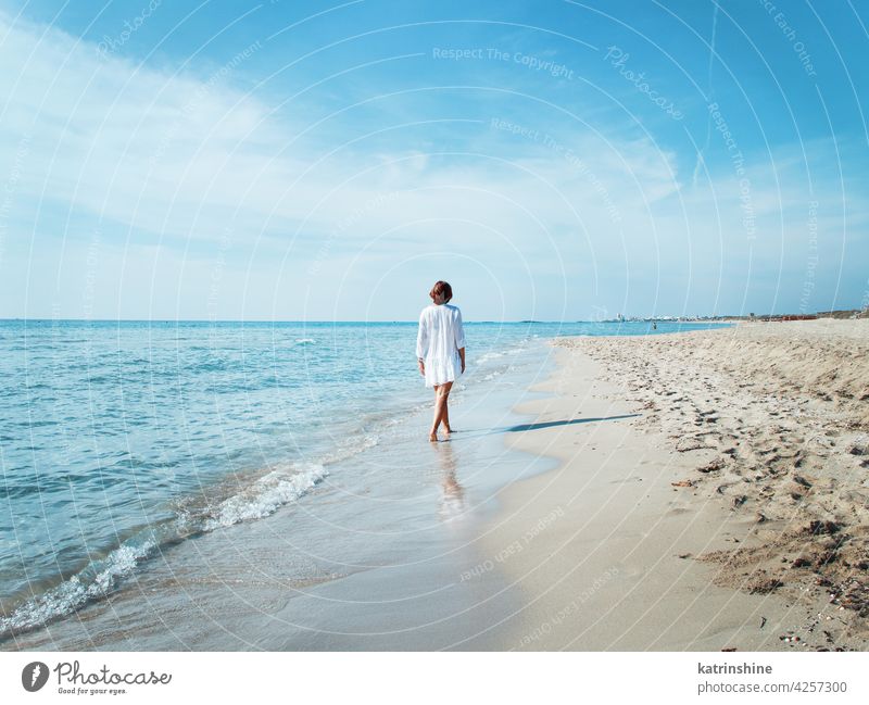 Junge Frau in der Abdeckung bis zu Fuß entlang des Strandes jung zudecken Spaziergang weiß blau türkis Rücken reisen Ferien Konzept Ausflugsziel im Freien