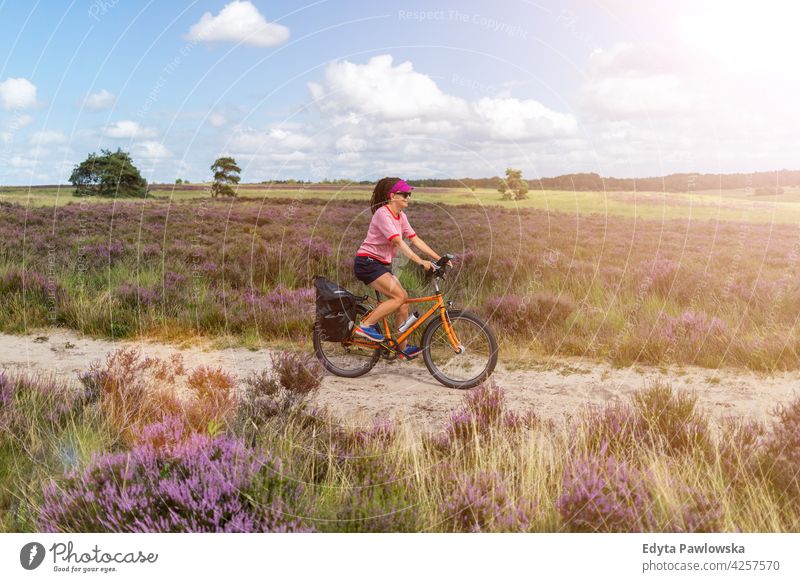 Junge Frau beim Fahrradfahren auf dem Land, Hoge Veluwe, Holland Menschen Radfahren Zyklus Kultur holländisch Europa Niederlande im Freien Natur Himmel Gras