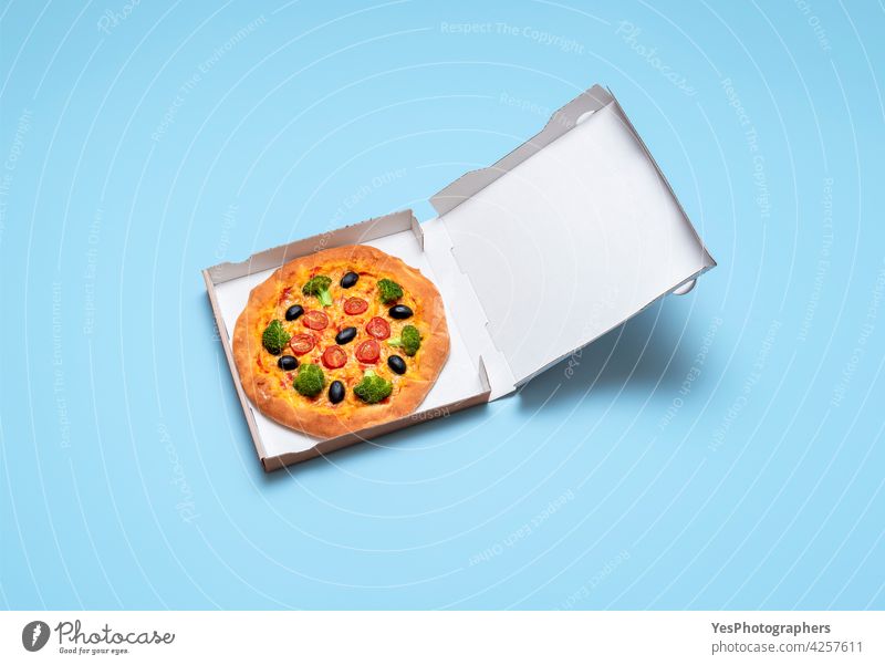 Vegane Pizza im Pappkarton. Gesunder veganer Pizzaservice oben Hintergrund gebacken blanko blau Kasten Brokkoli Karton Schachtel Käse Farbe Textfreiraum Kruste