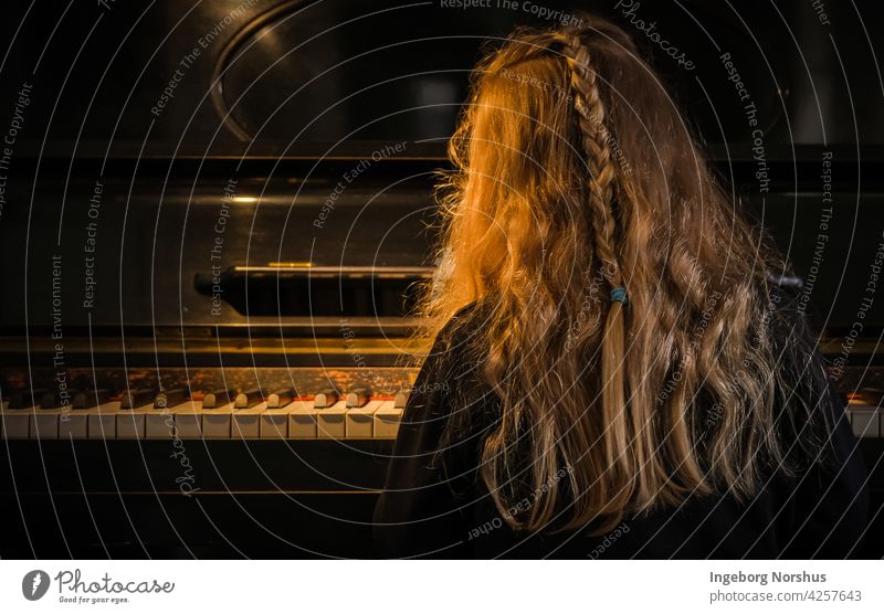 Mädchen spielt Klavier, Rückansicht, Standlicht Pianotastatur Licht & Schatten Stimmung Behaarung Frisur Kind Konzentration Geflecht eine Person