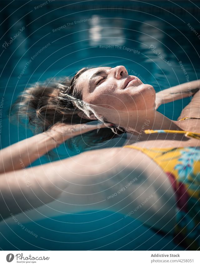 Entspannte Frau schwimmt im warmen Poolwasser Kälte Schwimmer schwimmen Badebekleidung Augen geschlossen sich[Akk] entspannen Vergnügen Inhalt feminin positiv