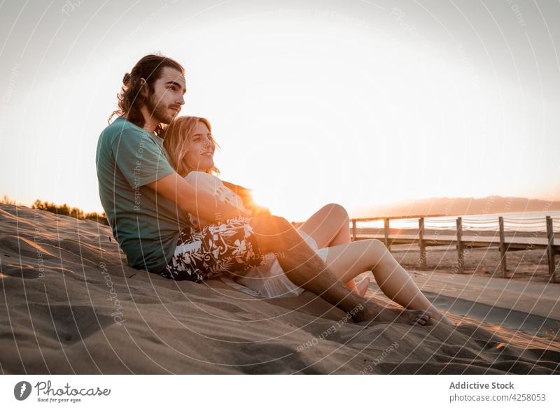 Romantisches Paar umarmt und liegt auf Sandstrand bei Sonnenuntergang Umarmung Gelassenheit Meeresufer Umarmen Strand romantisch Liebe Partnerschaft