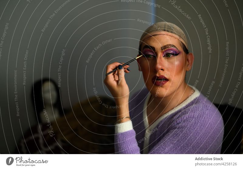 Weiblicher Mann beim Schminken in der Umkleidekabine androgyn feminin Drag Queen queer Make-up Gesicht exzentrisch Kosmetik Ankleidezimmer Individualität Stil