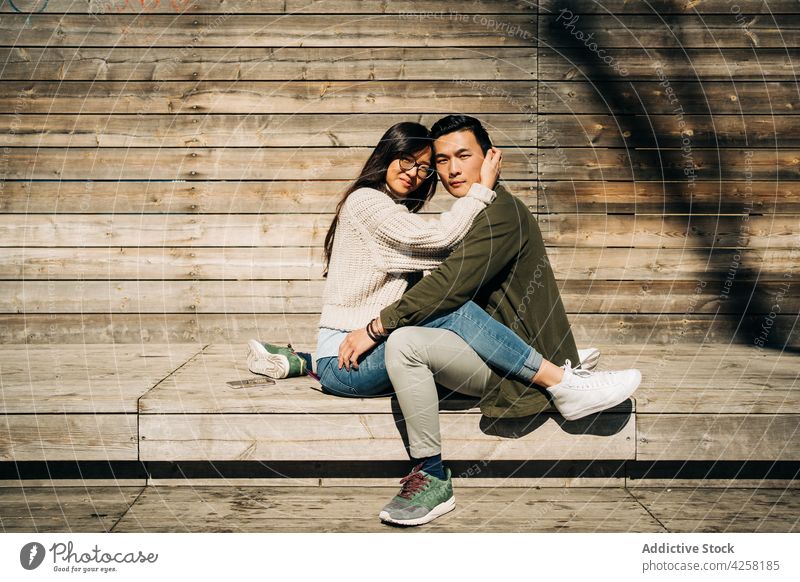 Geliebtes junges ethnisches Paar, das auf einer Bank im Park kuschelt Umarmen Liebe Zusammensein schließen Zuneigung Partnerschaft Glück ruhen hölzern Lächeln