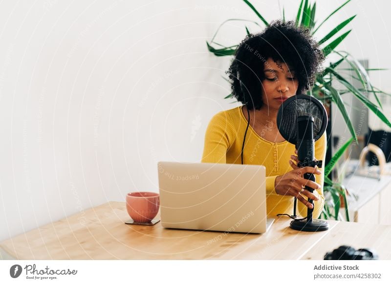 Junge afroamerikanische Frau im Gespräch bei einem Online-Radiosender Podcast reden Mikrofon Laptop Arbeit Aufzeichnen Kommunizieren Ausstrahlung