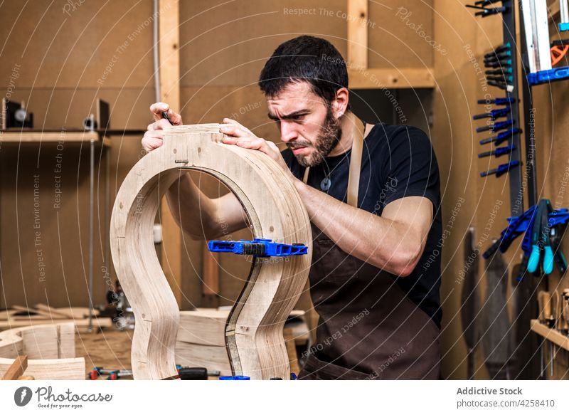 Geigenbauer baut Gitarre am Tisch in der Werkstatt Zupfinstrumentenmacher bauen Genauigkeit präzise Beruf Fähigkeit Mann Kleinunternehmen machen Musical